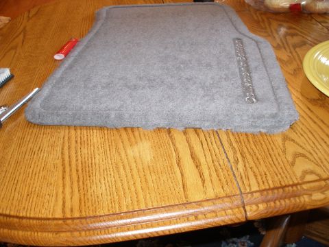 1998 Lincoln Mark VIII - A car floor mat with 'Collectors Edition' text is shown on a wooden table, next to cleaning supplies.
