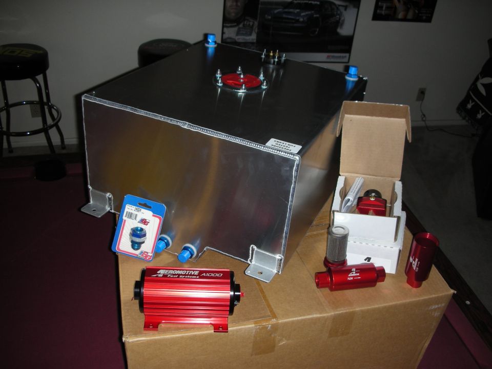Aluminum fuel cell with red Aeromotive A1000 pump, filters and AN fittings staged on box