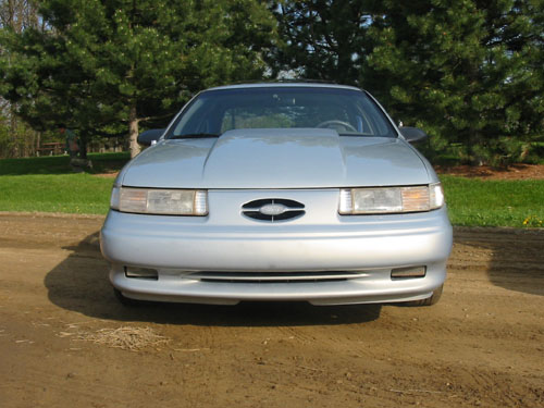 Silver 1994 Ford Taurus with a large aftermarket hood scoop, front view