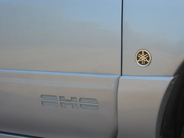 Car side panel showing 'SHO' emblem and a circular Yamaha logo badge