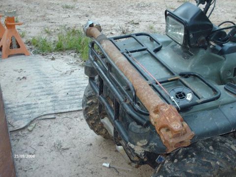 1990 Ford F-150 - A rusty driveshaft is secured to the rack of a green ATV.