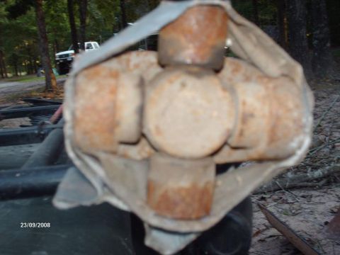 1990 Ford F-150 - Close-up of a rusty universal joint, likely part of a vehicle's drivetrain. Date stamp visible.