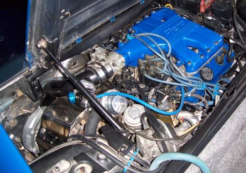 1988 Pontiac Fiero - Engine bay view shows blue valve covers with "Fiero" lettering, indicating a Pontiac Fiero engine.