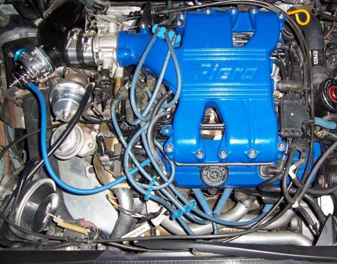 1988 Pontiac Fiero - Close-up of an engine bay a custom blue intake manifold with 'Fiero' branding.