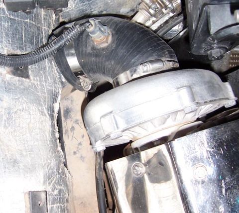 1988 Pontiac Fiero - A close-up view shows a turbocharger unit with associated plumbing and insulation.
