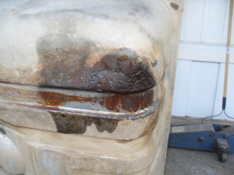 1990 Ford Bronco - Close-up of a heavily rusted and stained metal panel, possibly from a vehicle's undercarriage.