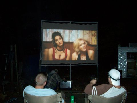 1991 Ford Bronco - People watch a movie on a large outdoor screen at night.