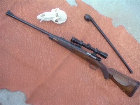 1991 Ford Bronco - A rifle with a scope, an animal skull, and a club are laid out on a textured surface.