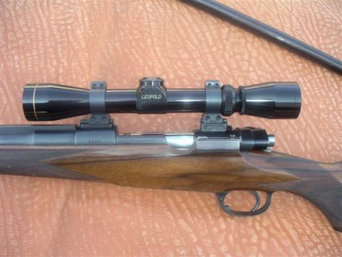 1991 Ford Bronco - A rifle with a Leupold scope is shown, mounted on the receiver.