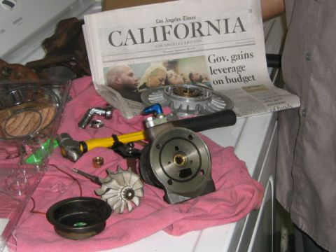 1995 Ford Probe - Various turbocharger parts are displayed on a pink cloth next to a copy of the Los Angeles Times newspaper.