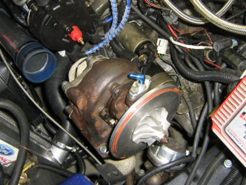 1995 Ford Probe - Engine bay detail showing a turbocharger and associated plumbing, with some wiring and a red electronic component visible.