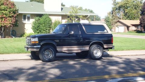1996 Ford Bronco - This 1996 Ford Bronco is parked on a residential street, showing its side profile.