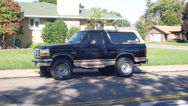 Black 1996 Ford Bronco parked curbside, side view