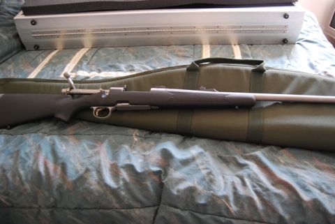 1991 Ford Bronco - A rifle rests on a green gun bag, with a metal case and bedding in the background.