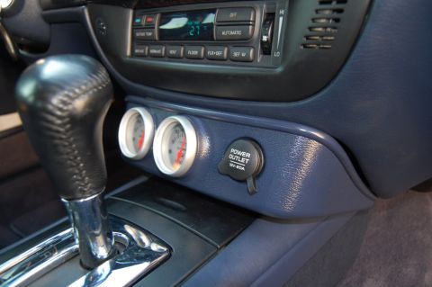 1985 Mercury Grand Marquis - The interior of a car displays a gear shifter, auxiliary gauges, and a power outlet.