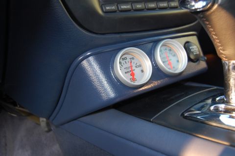 1985 Mercury Grand Marquis - Close-up of a car's dashboard showing oil pressure and temperature gauges, along with a 12V power outlet.