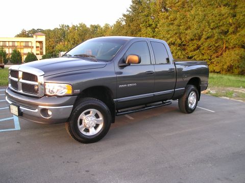 1989 Ford Bronco - This dark gray Dodge Ram 2500 pickup truck is shown from a 3/4 front angle, parked outdoors.