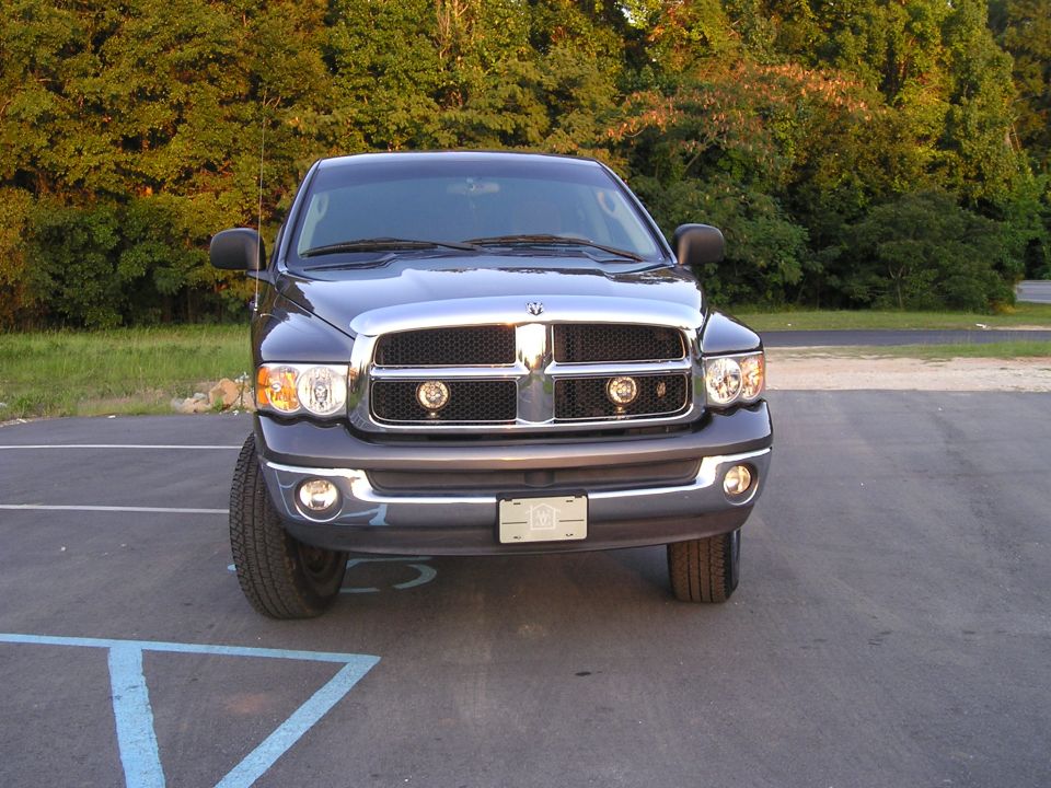Front view of dark blue pickup truck with chrome grille and fog lights