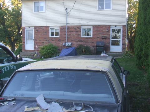 1982 Oldsmobile Cutlass - The interior and roof of a car are visible, with another vehicle parked to the left.