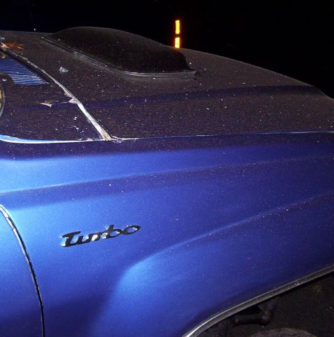 1986 Toyota Hilux - A close-up of a blue car's hood shows a hood scoop and a 'Turbo' emblem.