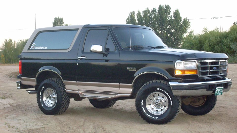 Black two-tone Ford Bronco 3/4 front view on dirt with BFGoodrich all-terrain tires