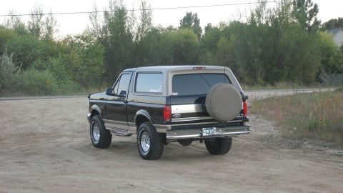 1996 Ford Bronco - The rear three-quarter view of a two-tone 1996 Ford Bronco shows its spare tire mounted externally.