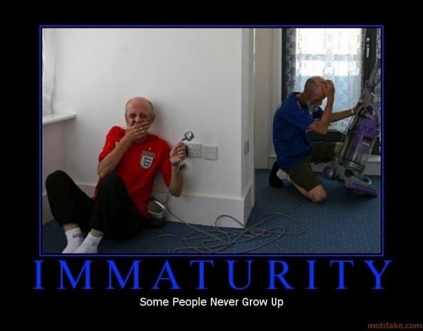 Man in red shirt holding plug, man in blue shirt with vacuum. Text says IMMATURITY