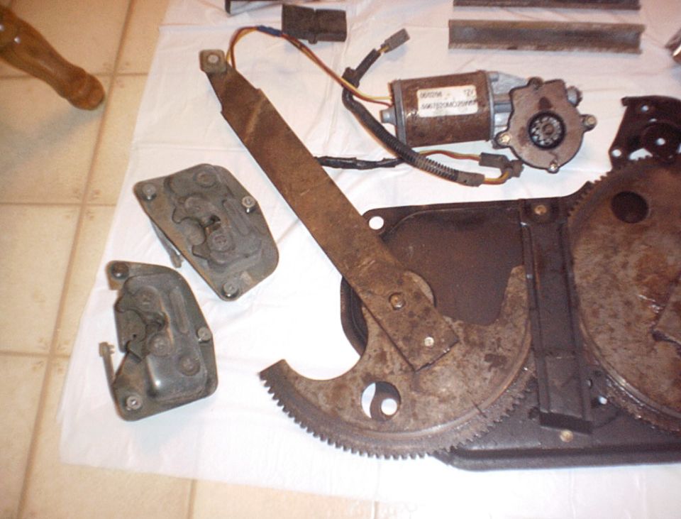 Window regulator mechanism with motor and gears, on a white cloth
