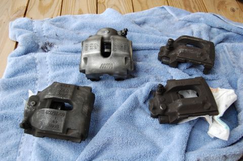 2002 BMW M3 - Four brake calipers are laid out on a blue towel, with one caliper clearly showing the M logo.