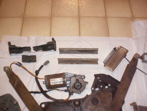 1986 Ford Bronco - Various car window regulator parts laid out on a white cloth.