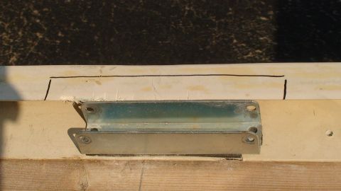 1979 Ford Bronco - A metal bracket is affixed to a surface, with visible markings and a wooden plank below.