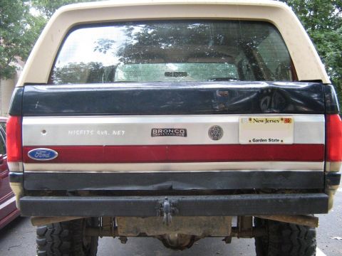 1990 Ford Bronco - Rear view of a 1990 Ford Bronco showing the tailgate with various stickers and a New Jersey license plate.