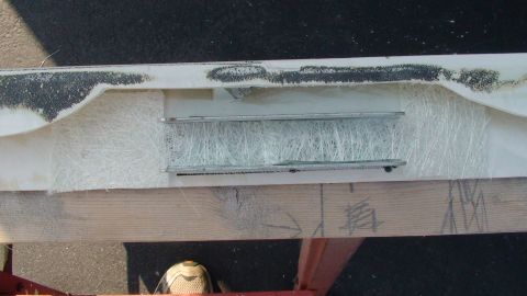1979 Ford Bronco - Close-up view of a vehicle part undergoing fiberglass repair, revealing internal bracing and raw material.
