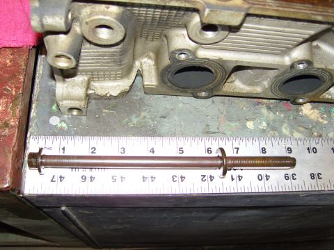 2007 Ford Mustang - A close-up view of an engine cylinder head with a bolt and ruler, indicating measurements.