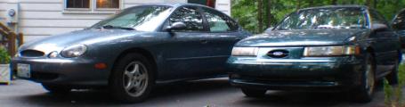 1993 Ford Taurus - Two Ford Taurus sedans are parked next to each other in a driveway.
