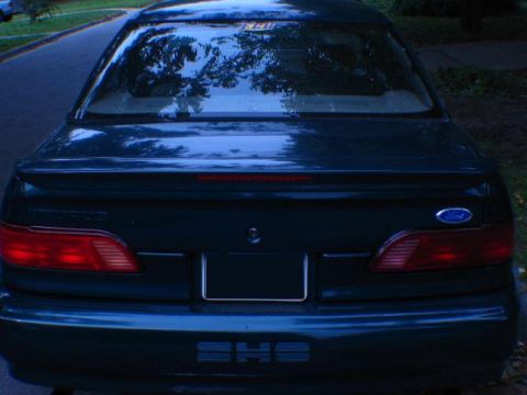 1993 Ford Taurus - The rear of a dark-colored 1993 Ford Taurus is shown, its taillights and SHO badging.