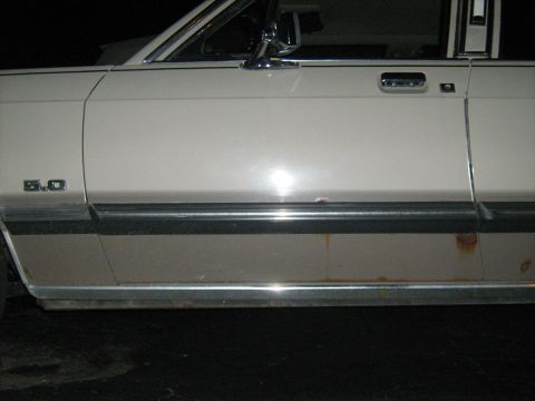 1988 Mercury Grand Marquis - This vehicle shows rust along the lower body trim and a '5.0' badge on the fender.