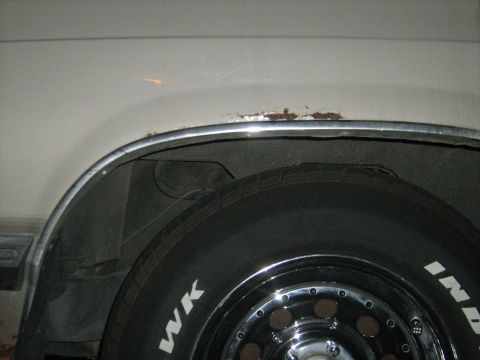 1988 Mercury Grand Marquis - Rust is visible on the chrome trim above the wheel well of a vehicle.