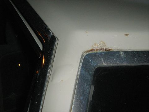 1988 Mercury Grand Marquis - Rust is visible on the corner of a car's roof, near the window trim.