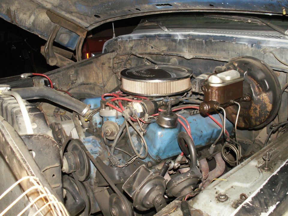 Engine bay of a blue 1977 Ford F-250 pickup truck with a blue engine block.