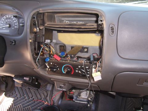 2003 Ford Ranger - The interior of a Ford Ranger dashboard is shown with the center console partially disassembled, revealing wiring and components. Visible e…