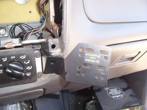 2003 Ford Ranger - Scosche FOR-201-95 metal radio mounting bracket fitted under a tan Ford dashboard with climate control knob visible.