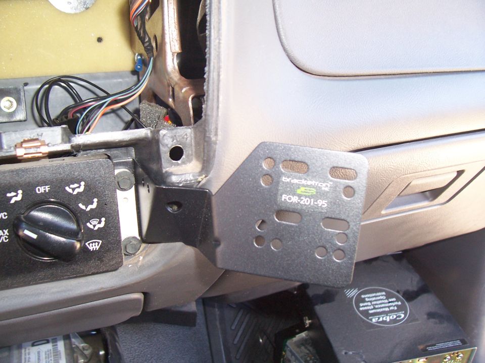 Black Scosche FOR-201-95 stereo dash mounting bracket installed under a Ford dashboard