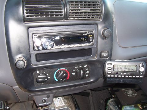 2003 Ford Ranger - Aftermarket CD head unit and a Cobra CB radio showing George Strait Baby Blue 1988, in a Ford truck center dash.