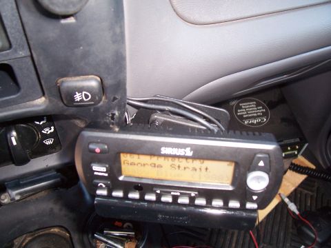2003 Ford Ranger - A close-up view of the dashboard of a vehicle, showing a Sirius satellite radio and a fog light switch.