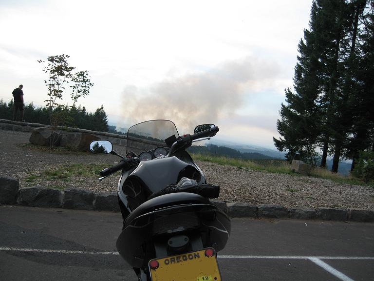 Black motorcycle from rear view, parked at scenic overlook with Oregon license plate.