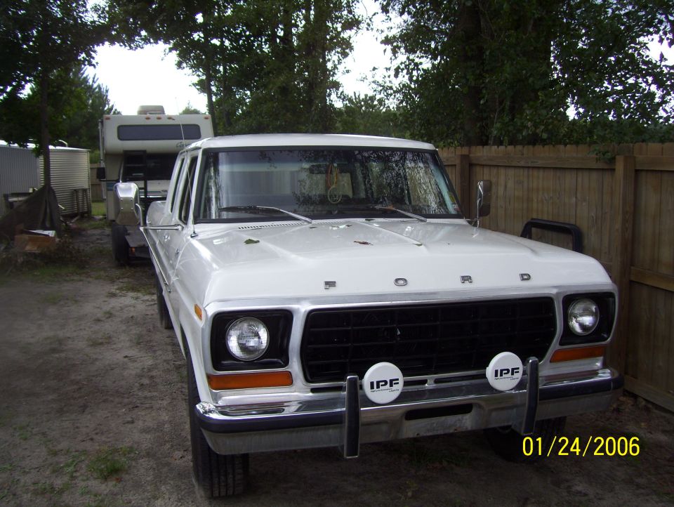 White 1970s Ford pickup truck with IPF fog lights parked outdoors.