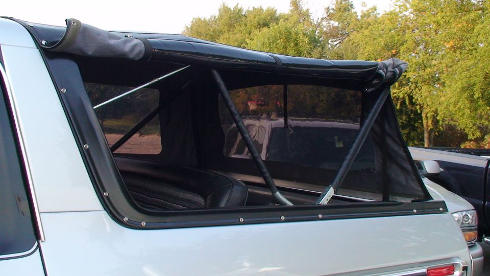 White Bronco with folded black soft top, tubular frame and clear vinyl windows