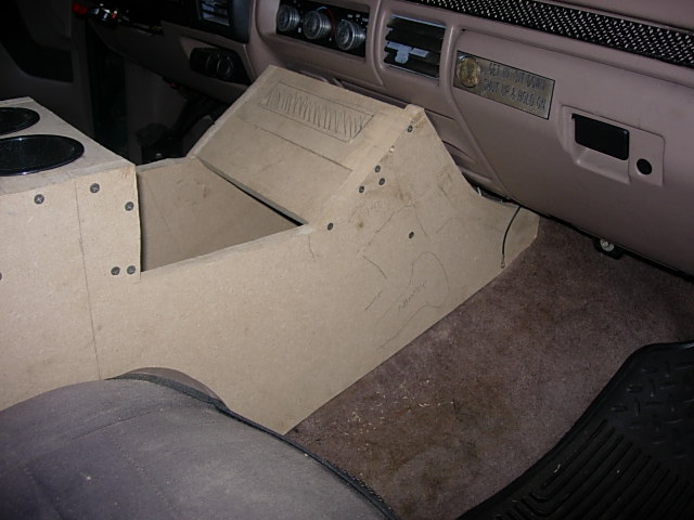 Raw MDF custom center console test-fitted in a tan truck interior