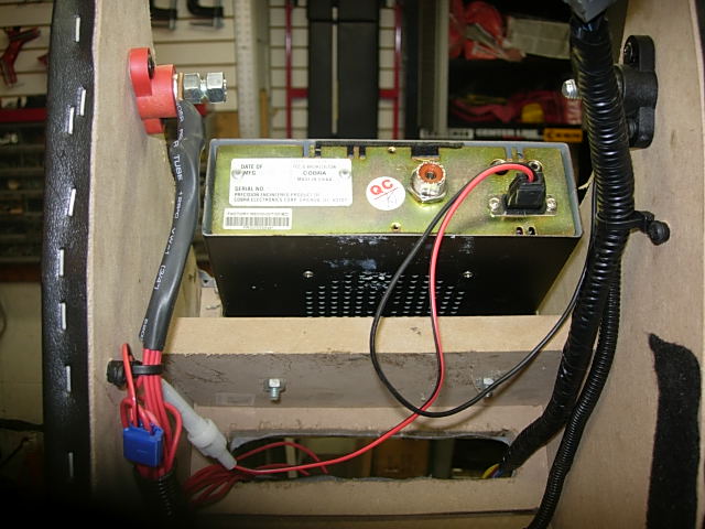 Rear view of a CB radio with wires connected inside a vehicle.